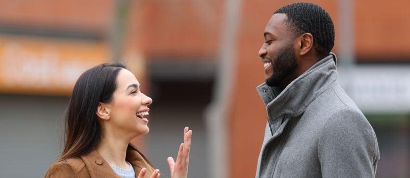 Happy couple talking while walking on street