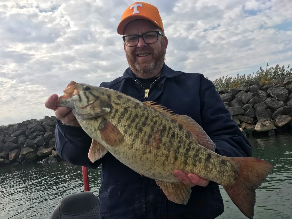 An angler holding a big Smallmouth Bass caught in Lake Erie.