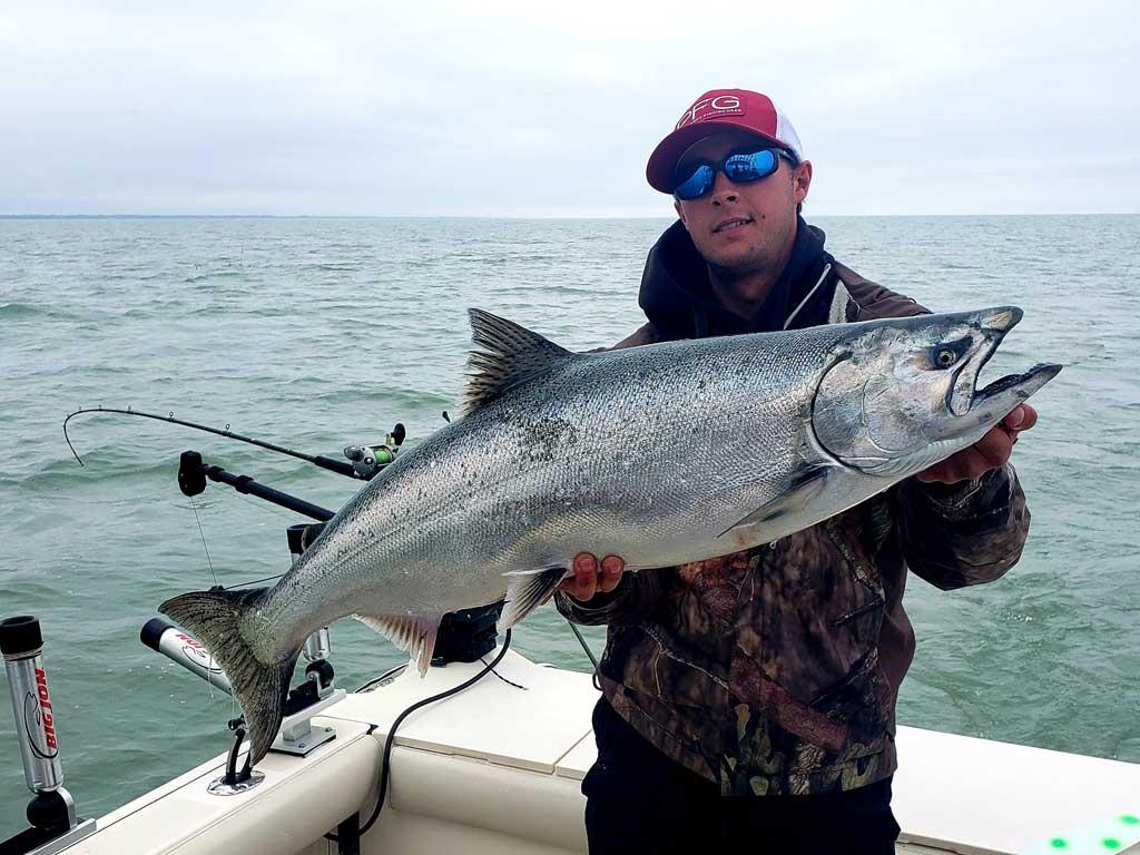 A man holding a large Steelhead caught fishing along Pennsylvania