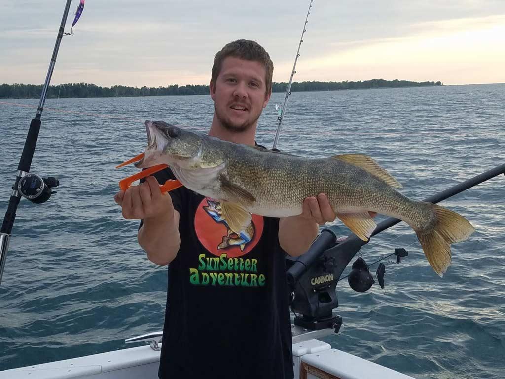 A man holding a Walleye reeled in on Lake Erie during the summer fishing season in Pennsylvania.