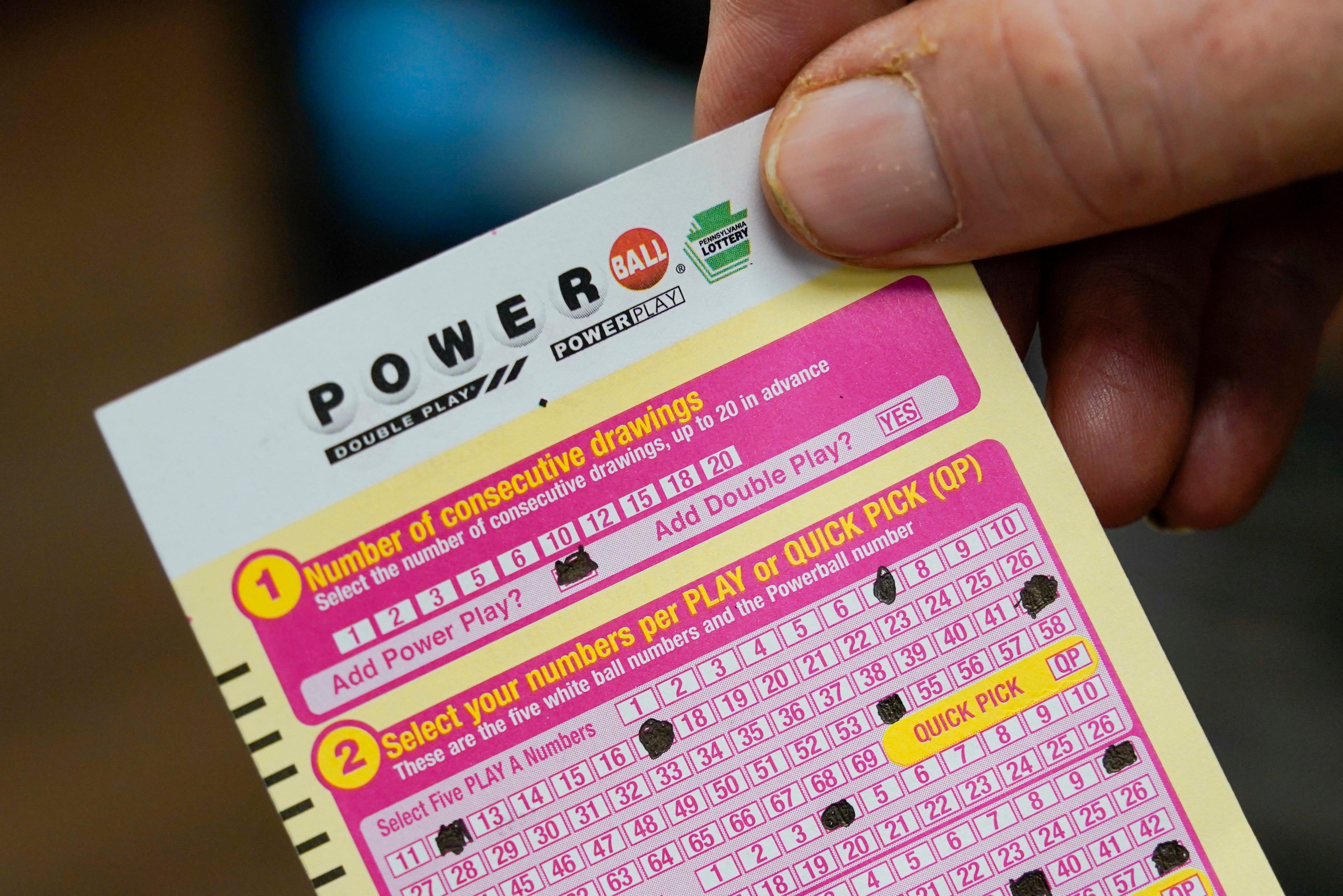 Steve Morton shows his scan card for his personal selection numbers for a ticket for a Monday Powerball drawing on Nov. 7, 2022, at a convenience store in Renfrew, Pa.