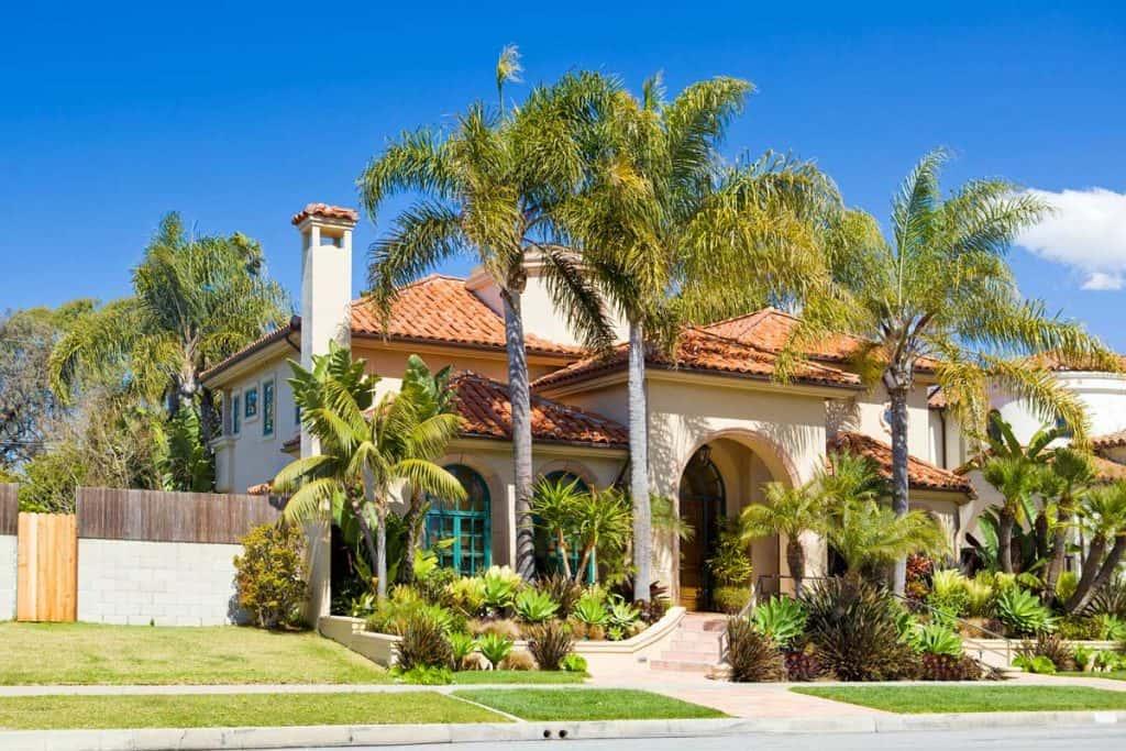 Palm trees in front of huge white mansion in southern california