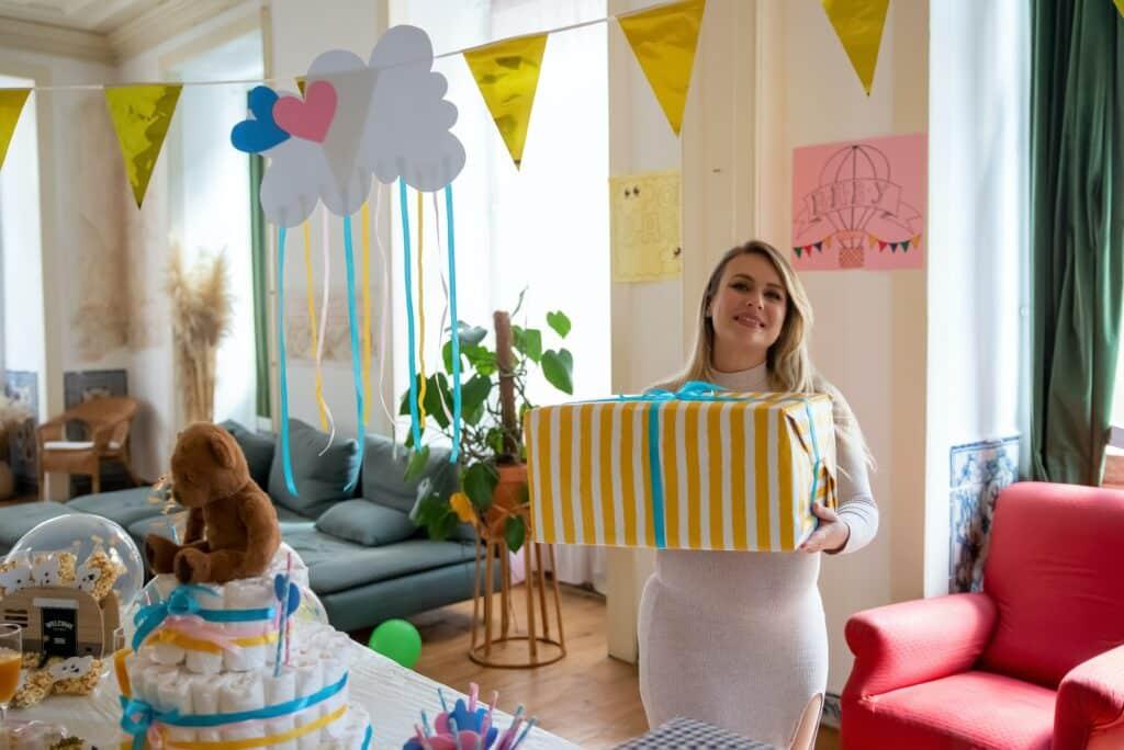 Pregnant woman holding gift at baby shower