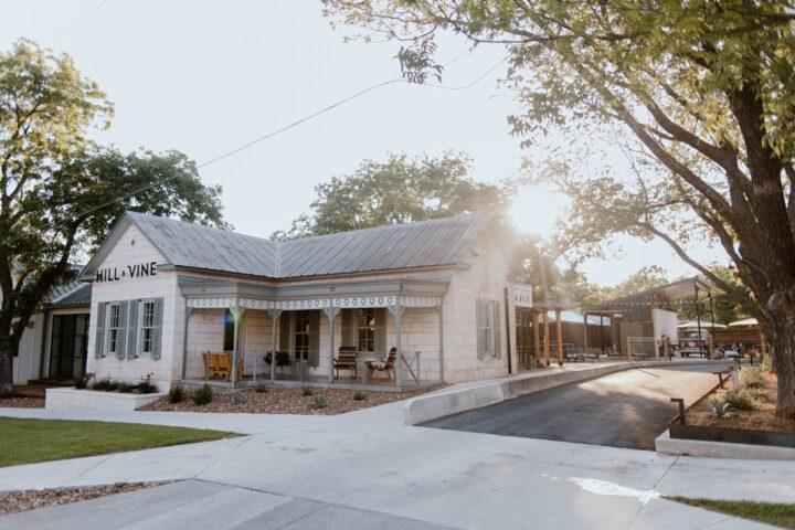 Hill and vine restaurant, a country chic Fredericksburg restaurant framed by rays of the setting sun and trees