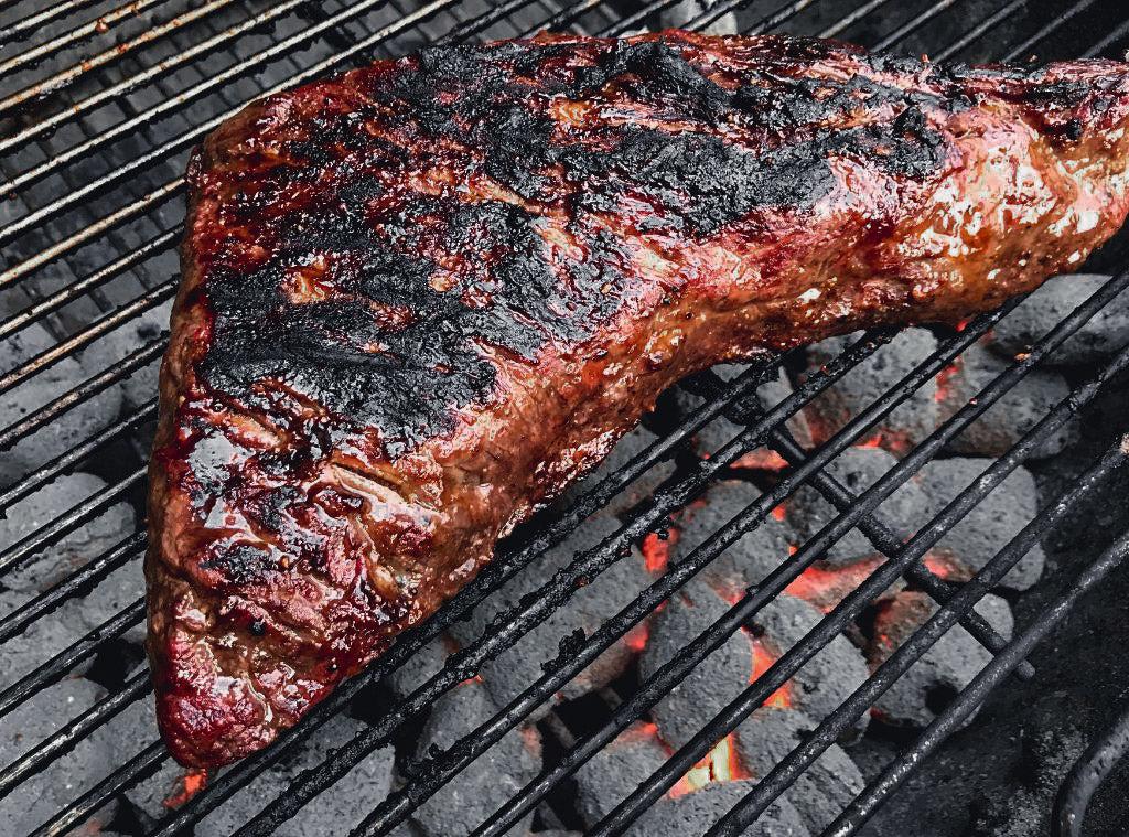 Photo of tri-tip steak on a charcoal grill