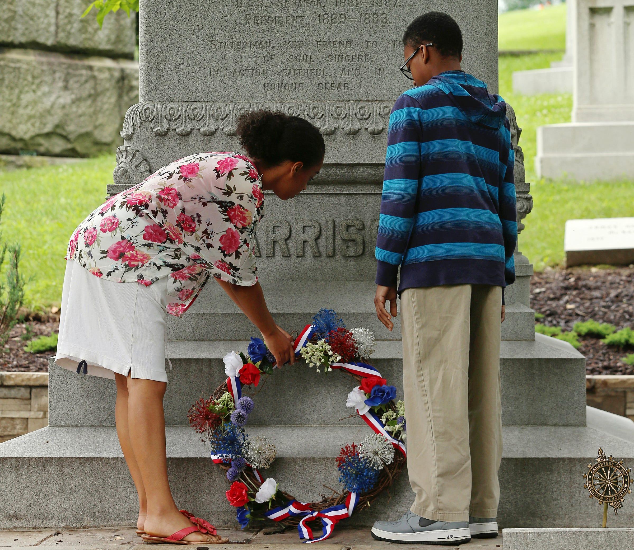 From left, Elisabeth Reese, 16, and Edwin Girton, 13, place a wreath on twenty-third president of the United States Benjamin Harrison