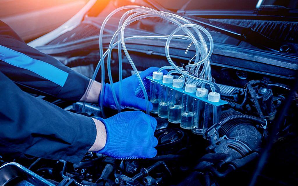 A mechanic testing ignition control module in a car