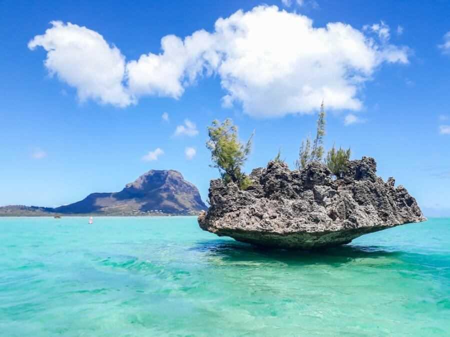 crystal rock floating in the middle of the lagoon with a mountain in the background