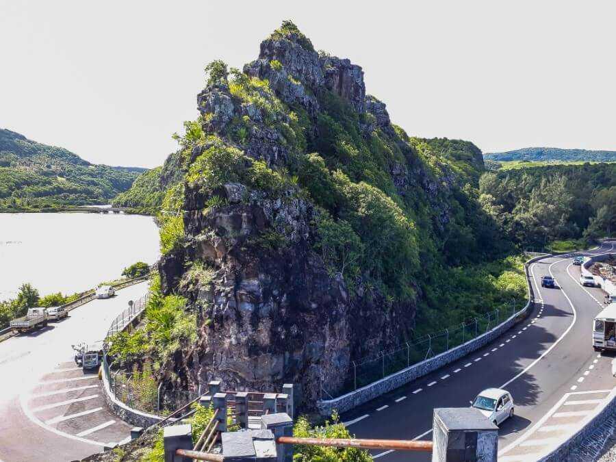 a huge rock formation covered with green vegetations at Macondé viewpoint