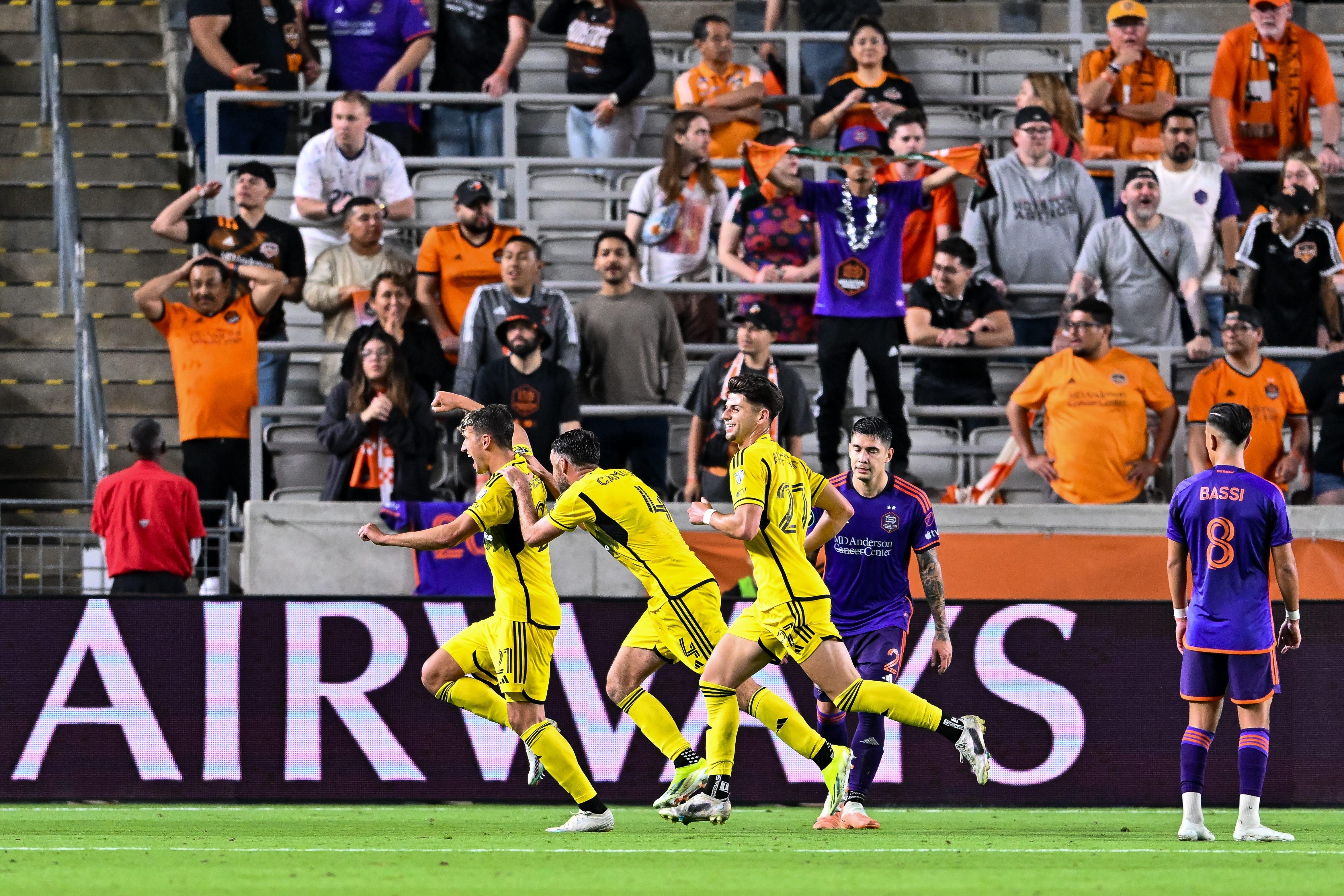 Mar 6, 2024; Houston, TX, USA; Columbus Crew defender Yevhen Cheberko (21), defender Rudy Camacho (4) and forward Max Arftsen (27) react to their teammate Columbus Crew midfielder Alexandru Matan (not pictured) goals during the second half against Houston Dynamo FC at Shell Energy Stadium. Mandatory Credit: Maria Lysaker-USA TODAY Sports