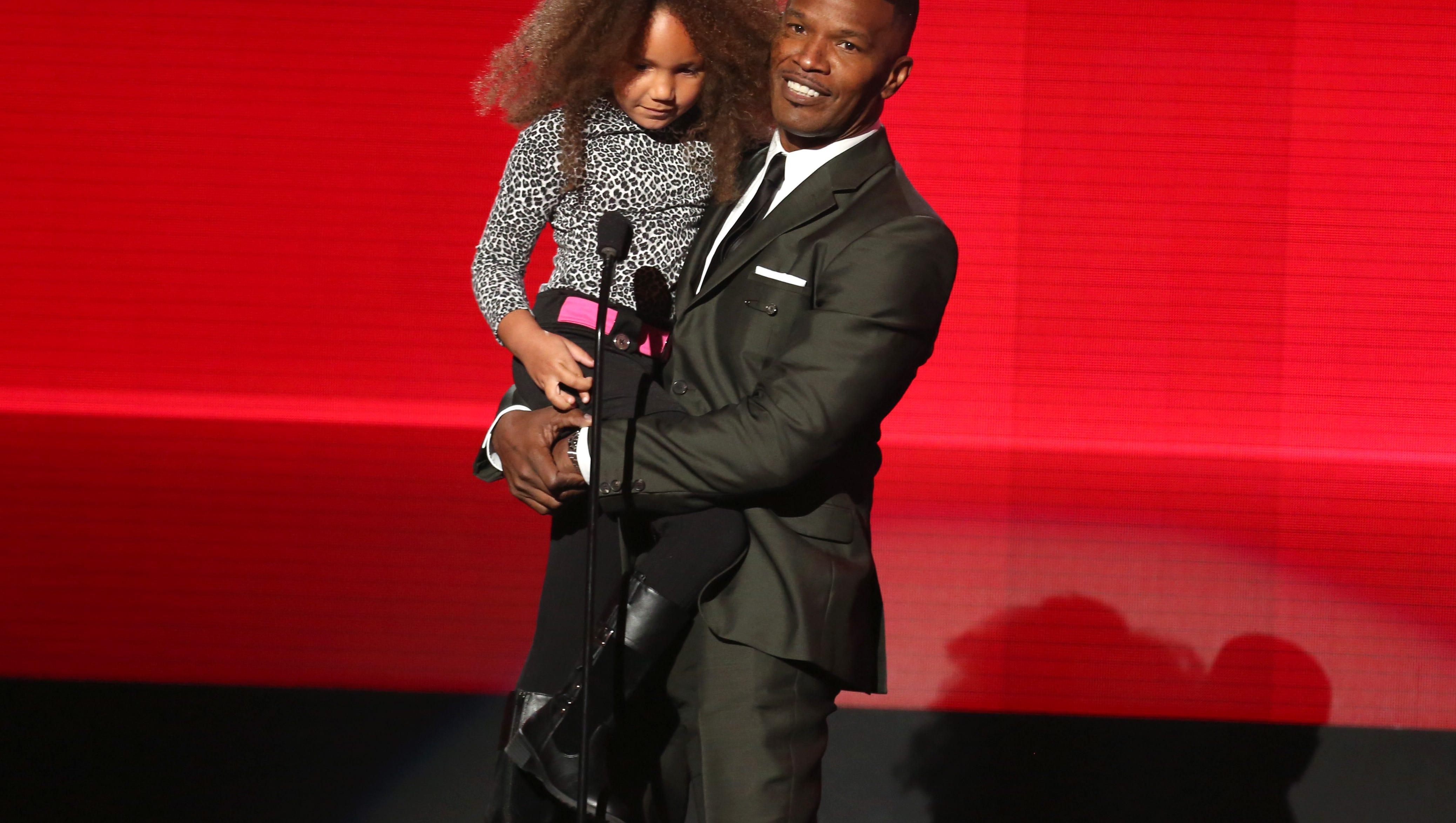 Annalise Bishop, left, and Jamie Foxx present the award for favorite rap/hip-hop album at the 42nd annual American Music Awards at Nokia Theatre L.A. Live on Sunday, Nov. 23, 2014, in Los Angeles. (Photo by Matt SaylesInvision/AP)