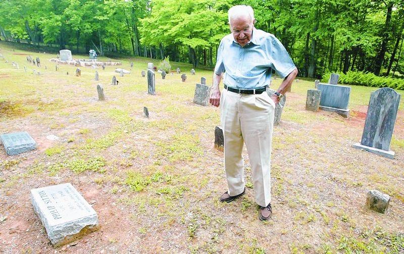 Bert Sitton looks over some of the graves at the Sitton Gillespie Cemetery off South Mills River Road. Sitton has helped work on the upkeep of the cemetery.