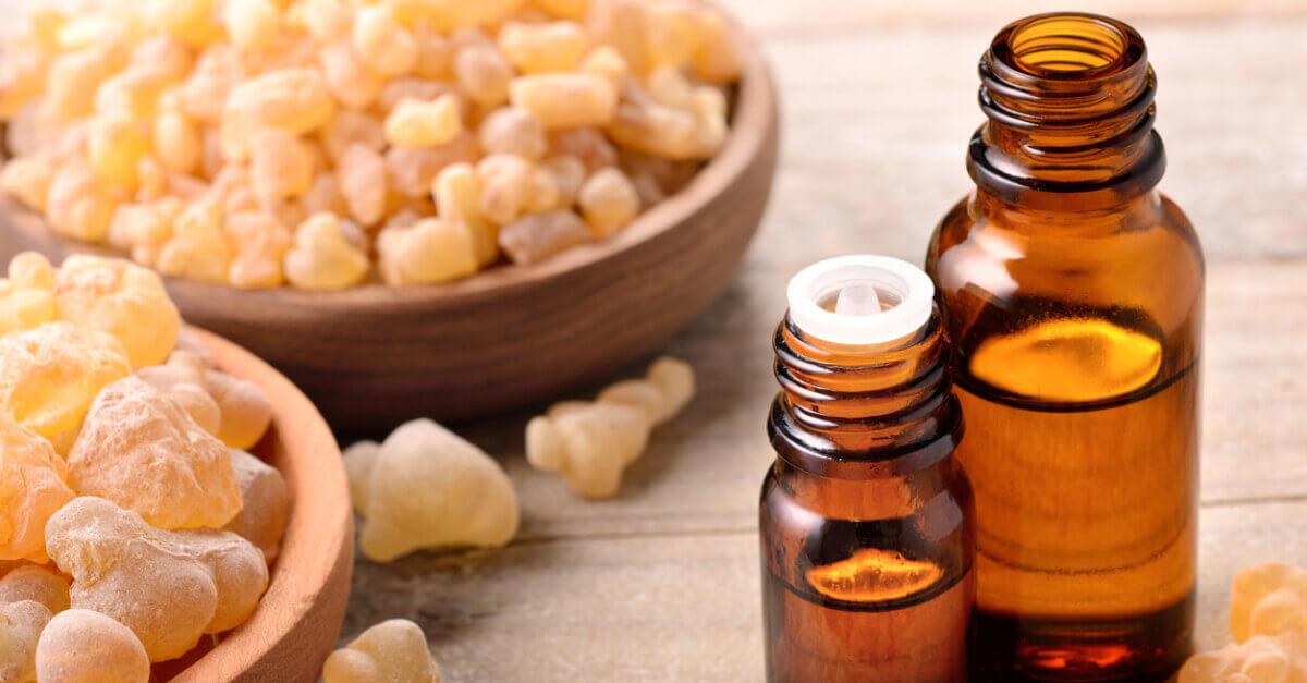 Frankincense resin in bowls with full essential oil bottles