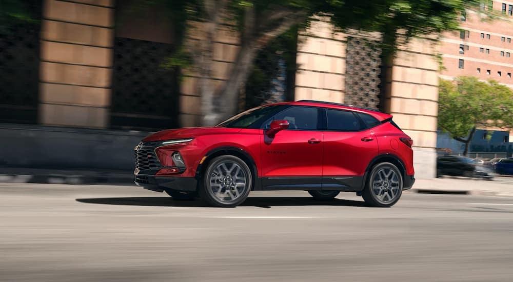 A red 2023 Chevy Blazer RS driving on a city street.