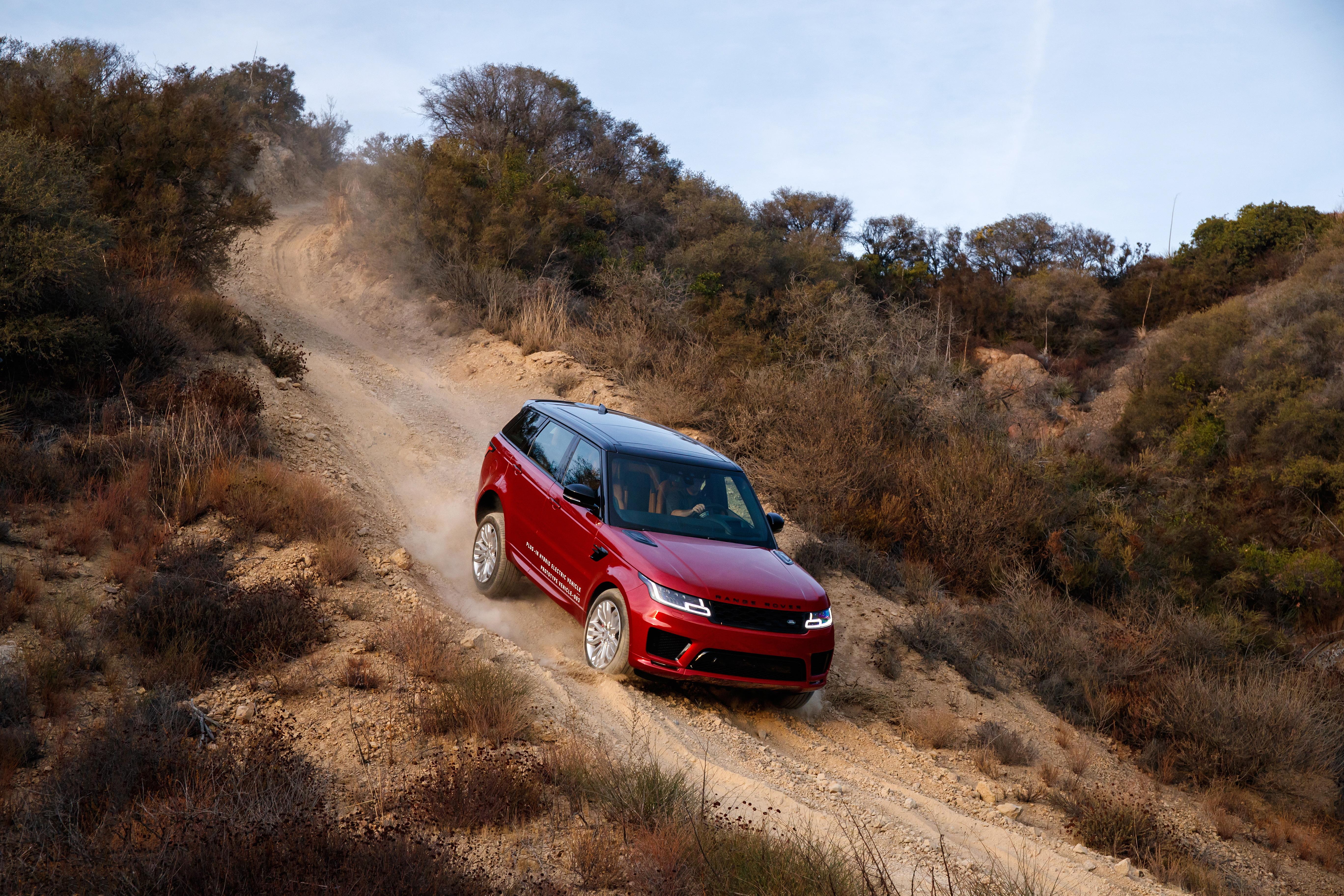 A silver Range Rover Evoque against a mountain backdrop