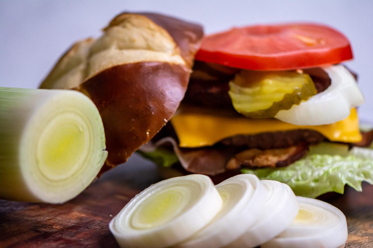 leeks sliced in front of a burger.