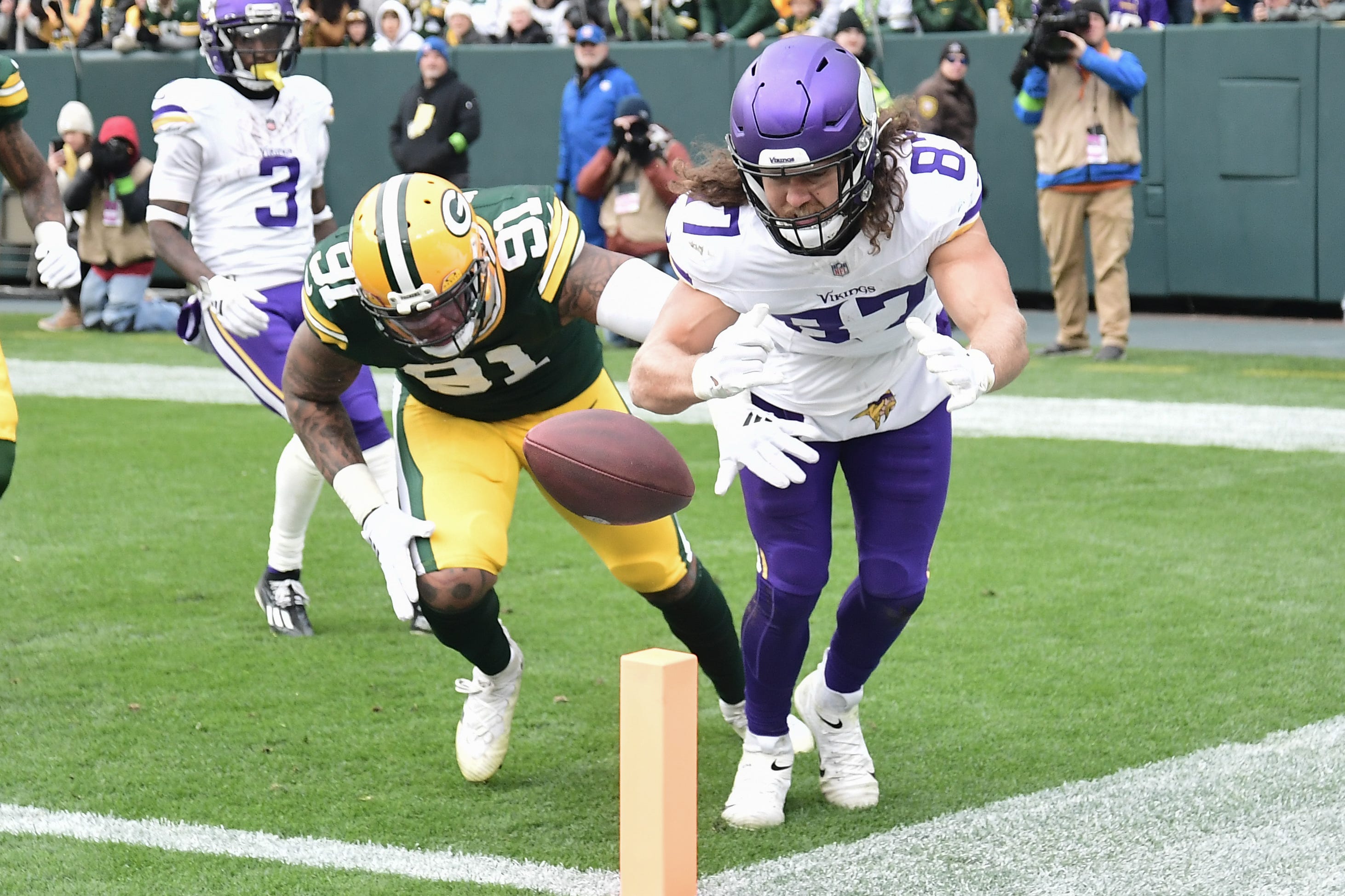 Green Bay Packers linebacker Preston Smith tries to keep Minnesota Vikings tight end T.J. Hockenson (87) out of the end zone.