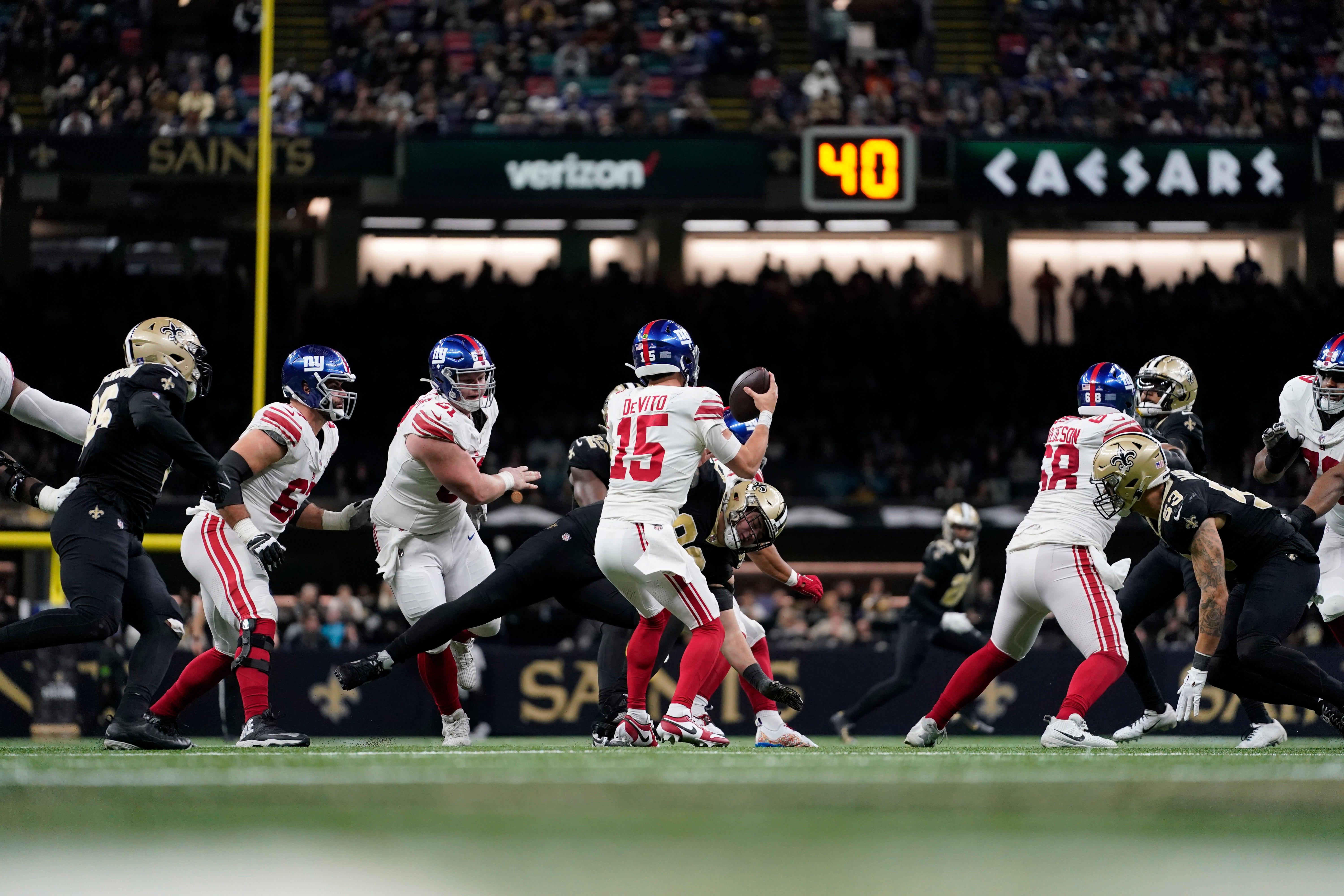 New York Giants quarterback Tommy DeVito (15) protects the ball under pressure from New Orleans Saints defensive tackle Bryan Bresee (90) during the second half of an NFL football game Sunday, Dec. 17, 2023, in New Orleans. (AP Photo/Gerald Herbert)