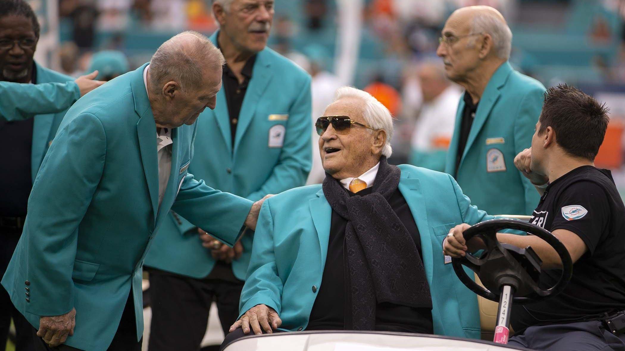 Coach Don Shula talks with Jim Kiick (left) with Larry Csonka and Manny Fernandez in the background. The Miami Dolphins 1972 team celebrated being named the best NFL team ever during a halftime ceremony at Hard Rock Stadium in Miami Gardens, Dec. 22, 2019.