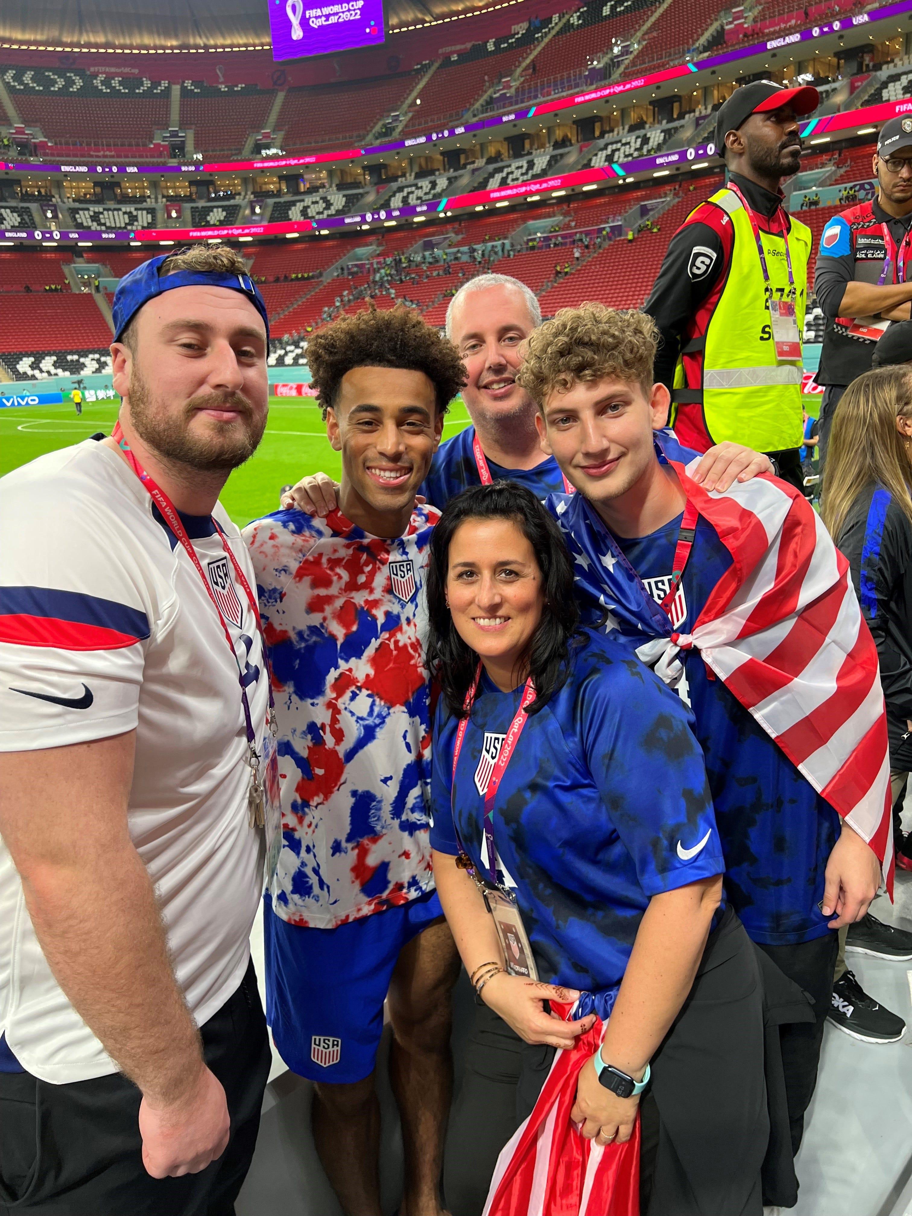 Tyler Adams poses with his family in the stands at Al Bayt Stadium in Qatar after helping the United States play to a scoreless tie against England in the World Cup on Nov. 25, 2022. From left: Darryl Sullivan Jr., Tyler Adams, Darryl Sullivan Sr., Melissa Russo and Donovan Sullivan.