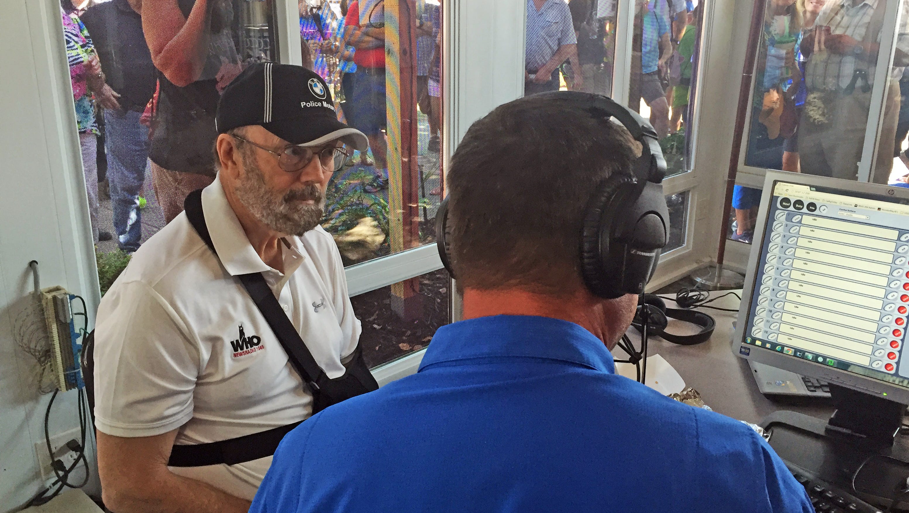 Jan Mickelson, left, chats with former Republican state Sen. Jeff Angelo, who has substituted for Mickelson on WHO-AM 1040 while the radio host has recovered from a stroke. Listeners peek through the plate-glass windows.