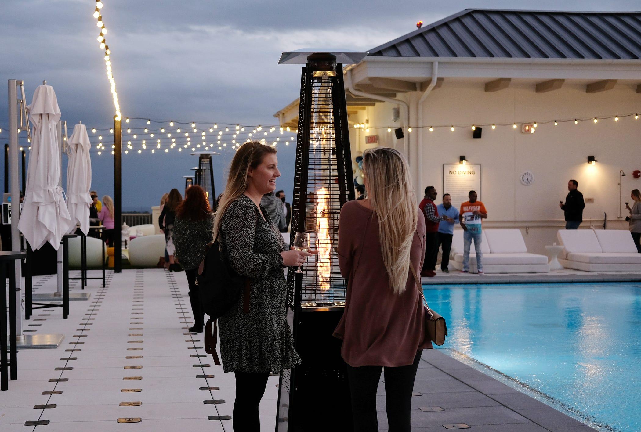 Guests enjoy the ambiance of the rooftop pool and bar during the public grand opening for Hotel Effie next to The Village of Baytowne Wharf.