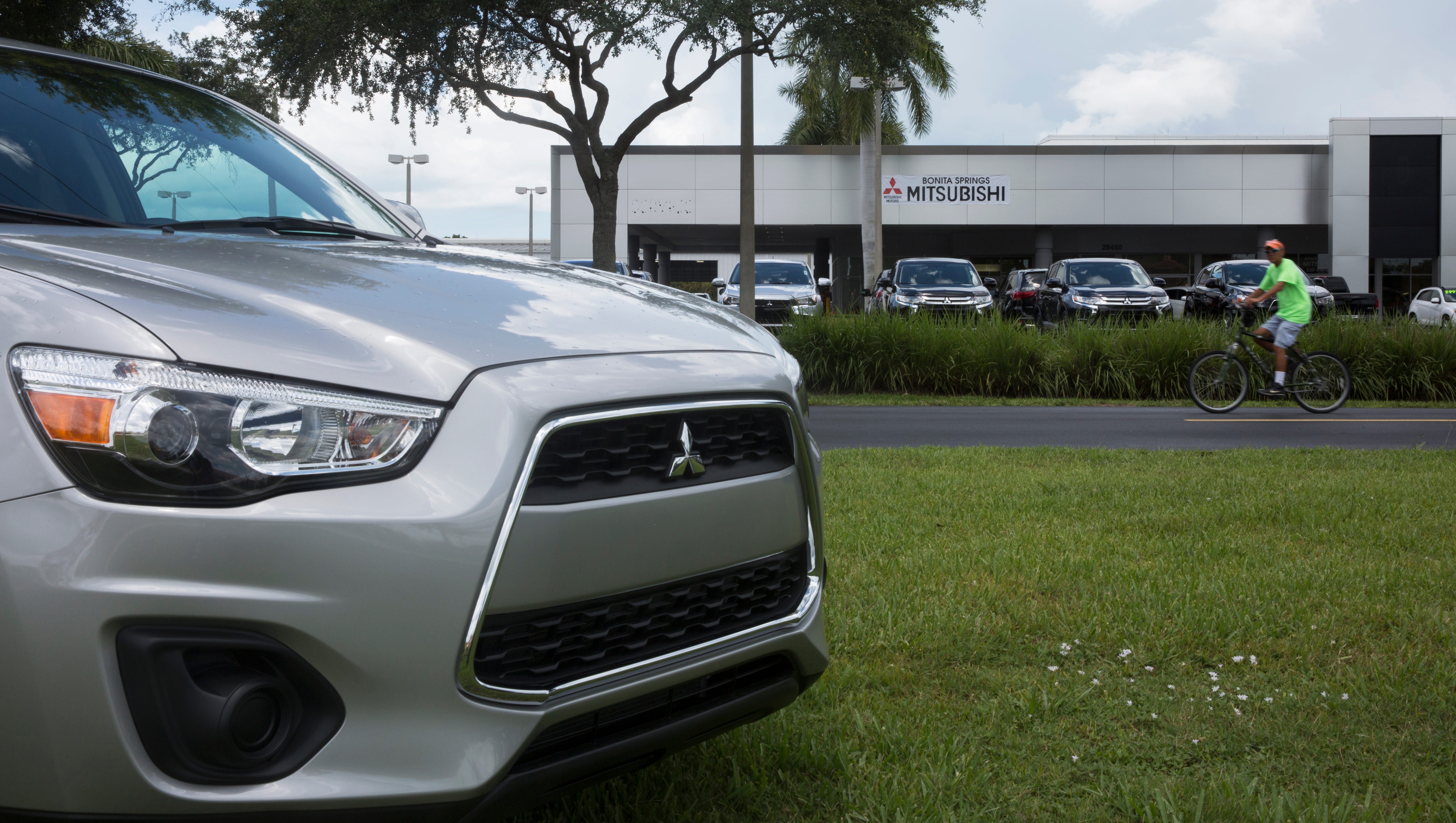 A man bikes past the new Mitsubishi dealership on July 14, 2016, in Bonita Springs. Opening last weekend, the Naples-Bonita Springs area provides a great and competitive market for the new and expanding dealership.