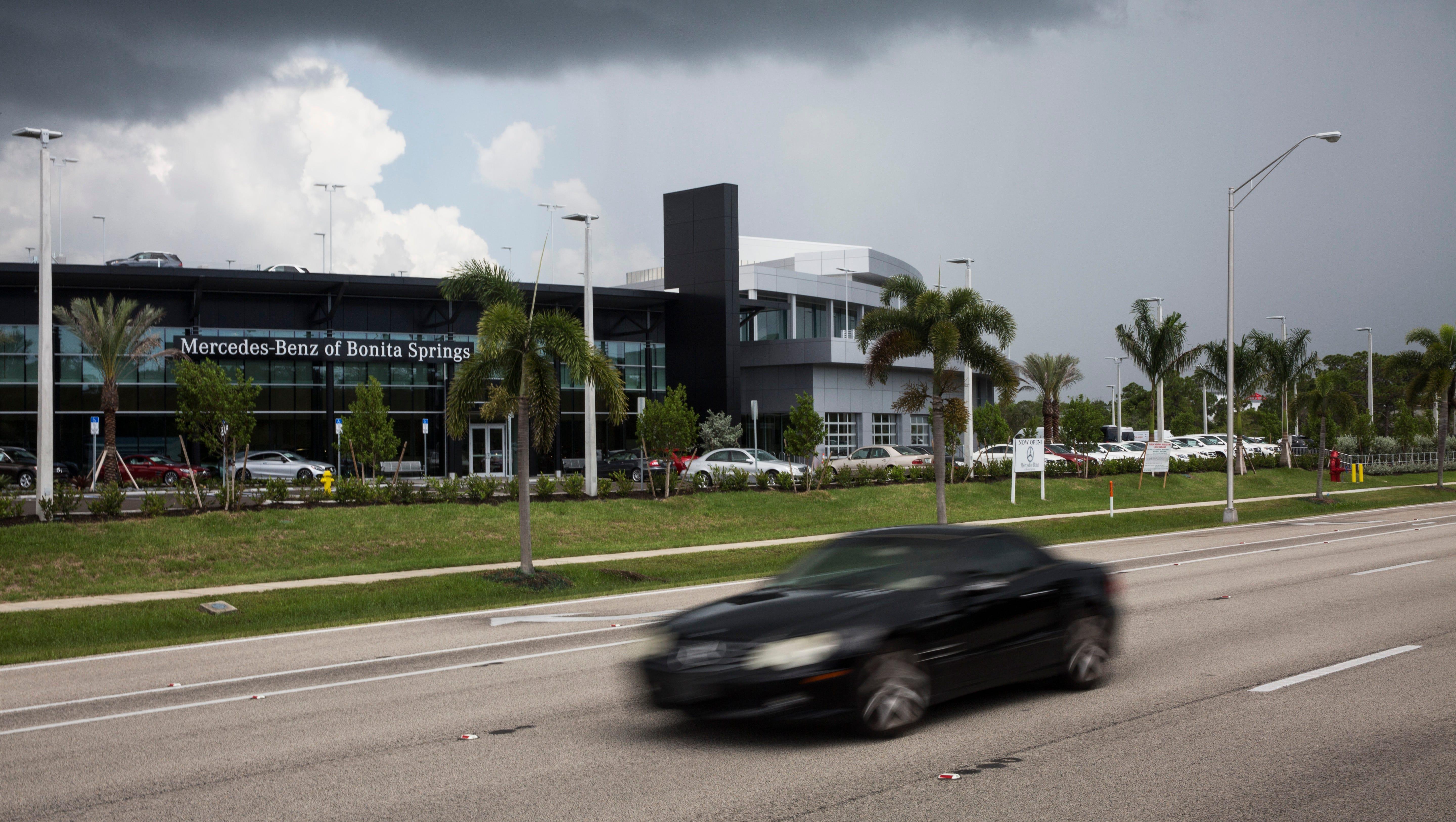 A Mercedes-Benz drives in front of the Mercedes-Benz dealership in Bonita Springs, Florida.