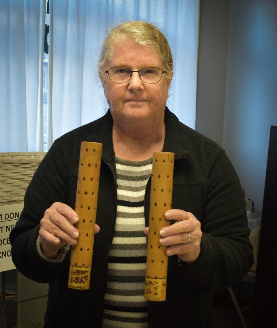 Bellevue Historical Society Treasurer Mary Mitchell holds vintage Dum Dums display holders at the society office. The holders were donated from the estate of Bill Oddo, a past president of the society and a Bellevue history expert.