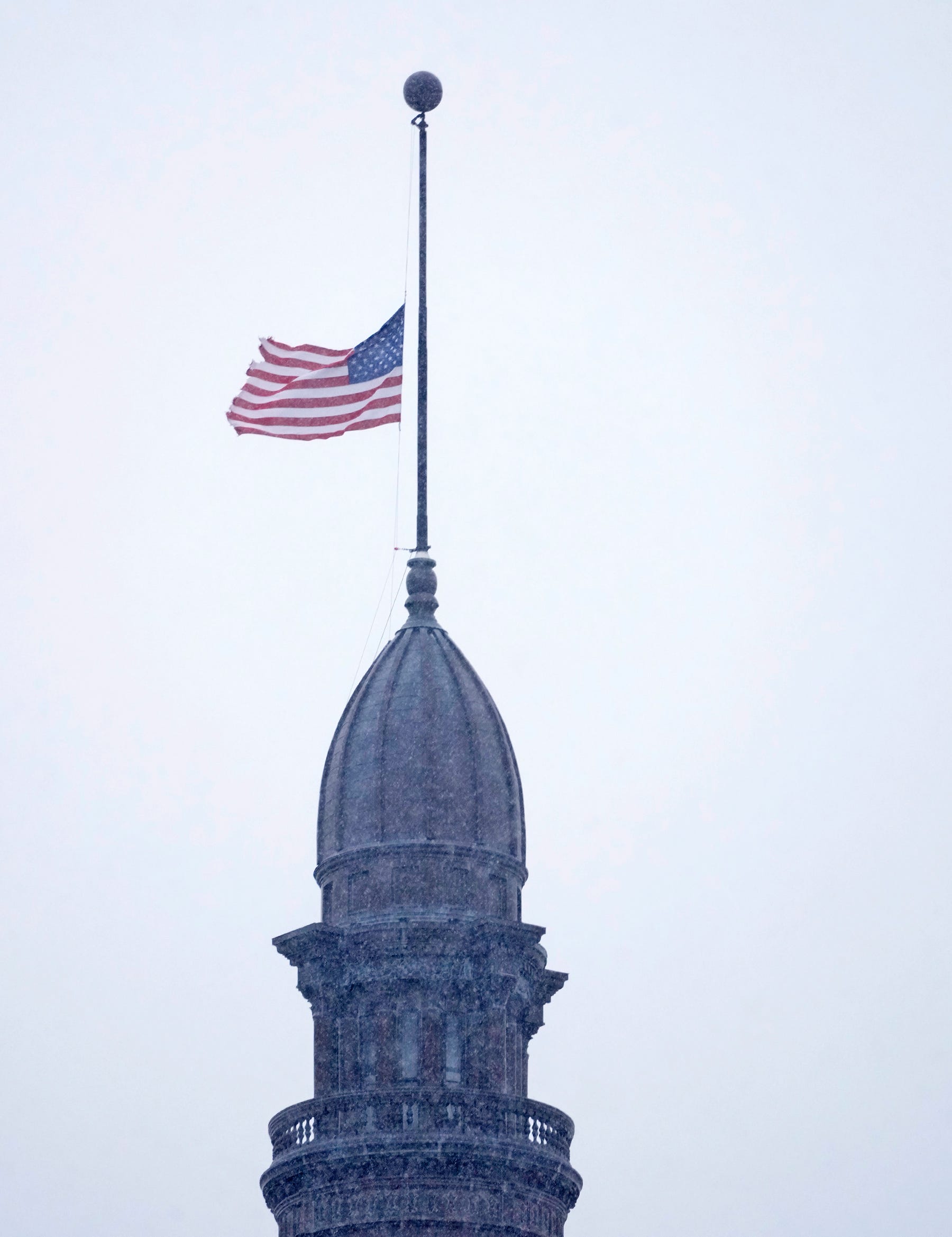 The American Flag flies at half staff at Milwaukee City Hall in Milwaukee on Thursday, Dec. 22, 2022. Gov. Tony Evers has ordered the American and Wisconsin flags to be flown at half-staff Thursday in honor of Aundre Cross, the U.S. Postal Service mail carrier who was shot and killed Dec. 9.