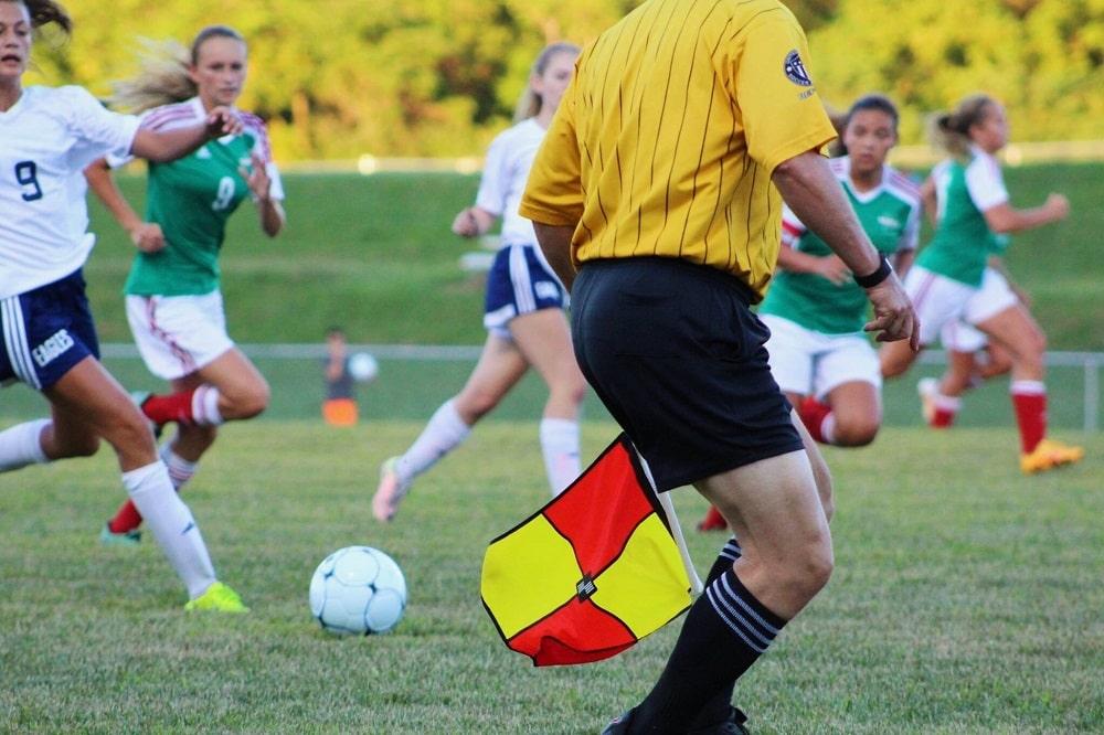 A close look at a referee officiating the soccer match.