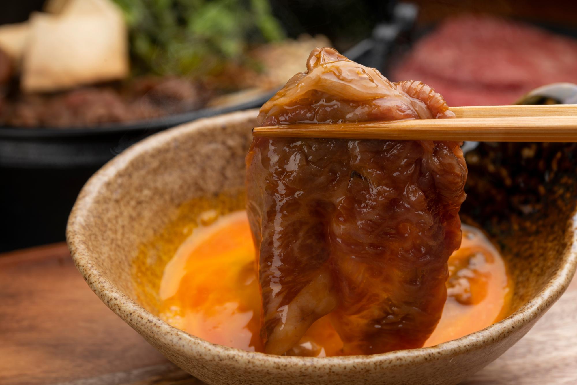 sukiyaki being dipped in eggs kai keisuke © Shutterstock