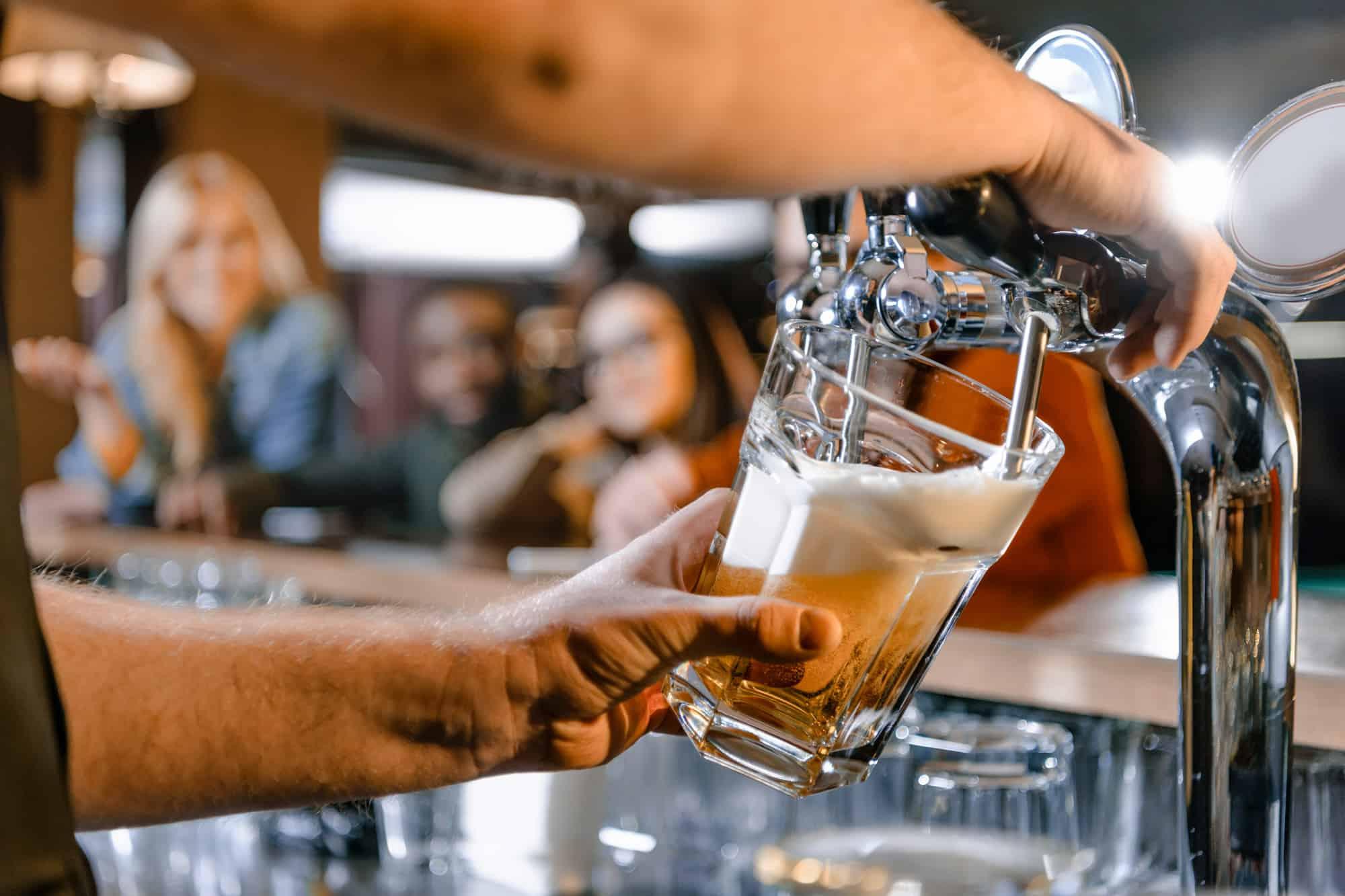 a bartender pours a beer on tap