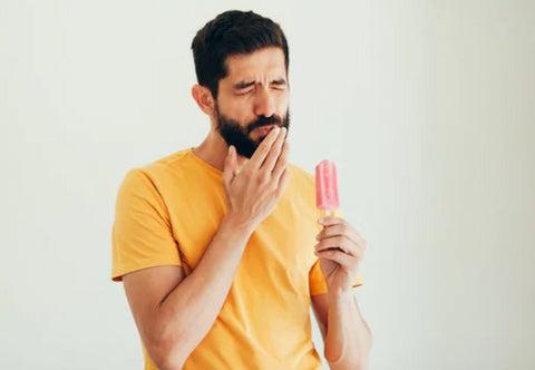 a man with ice-cream having troubles with his teeth