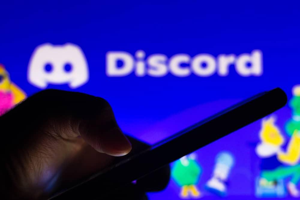 holding phone infront of discord logo