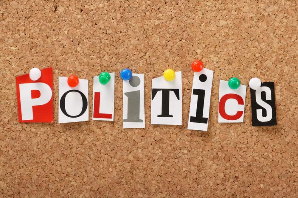 The word Politics in cut out magazine letters pinned to a cork notice board