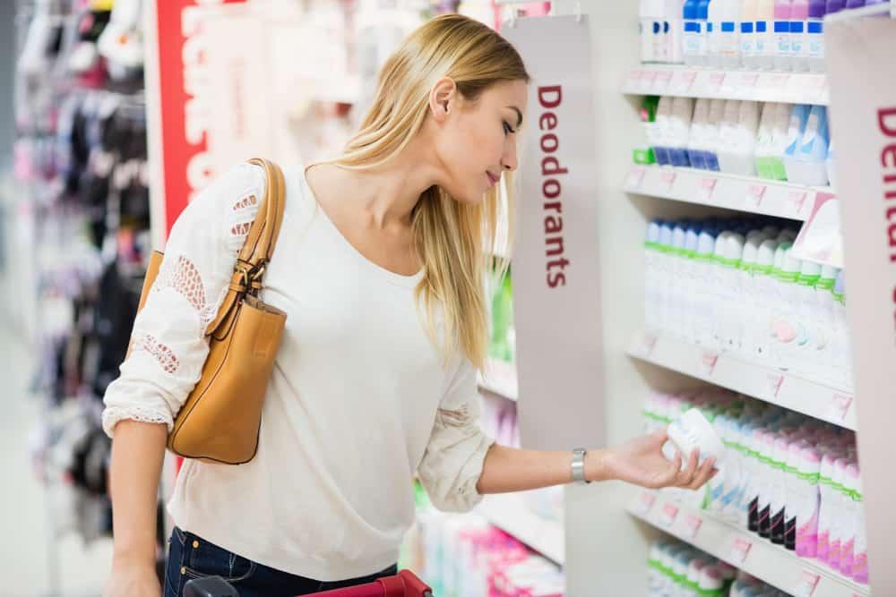 Side view of woman choosing deodorant at supermarket