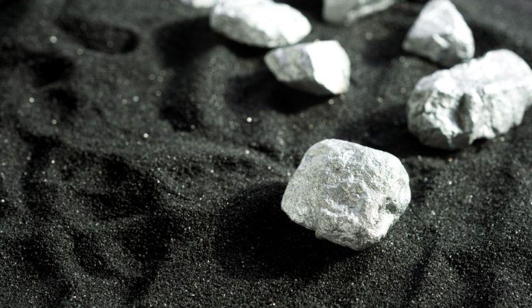 pure platinum rock from the mine placed on black sand