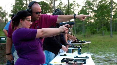 A man showing a lady where to shoot