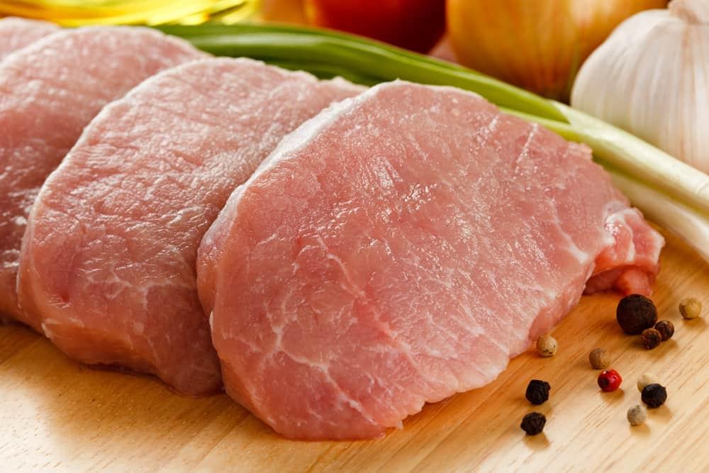 Raw pork chops on cutting board