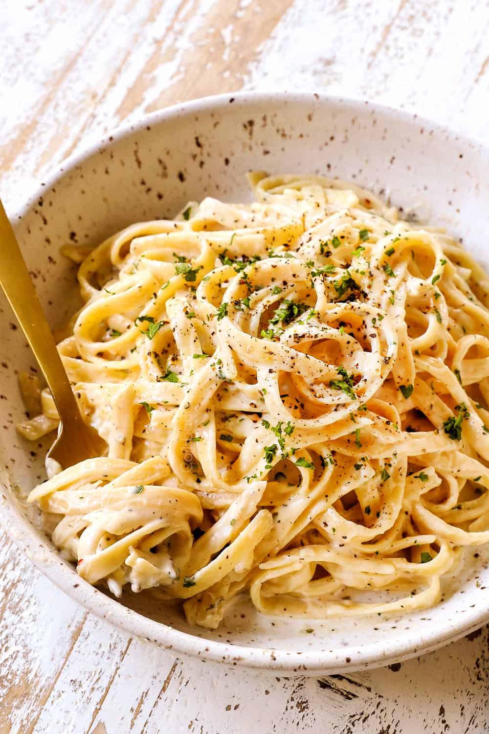 homemade fettuccine Alfredo in a bowl with a fork