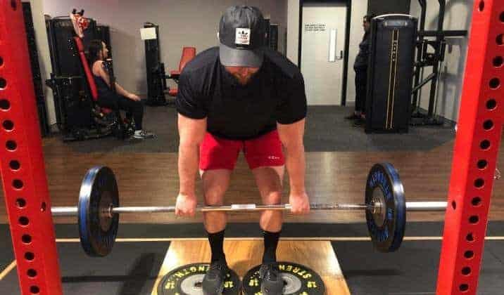 deficit deadlift is performed while standing on an elevated surface ranging from 1-4 inches, such as a weight plate or small riser