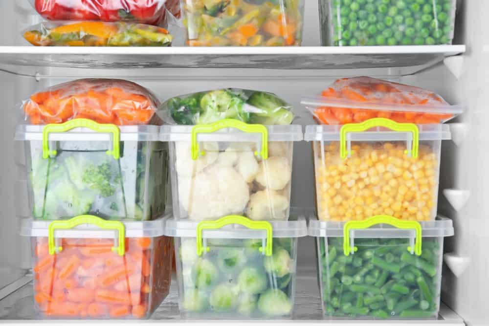Containers with deep frozen vegetables in refrigerator