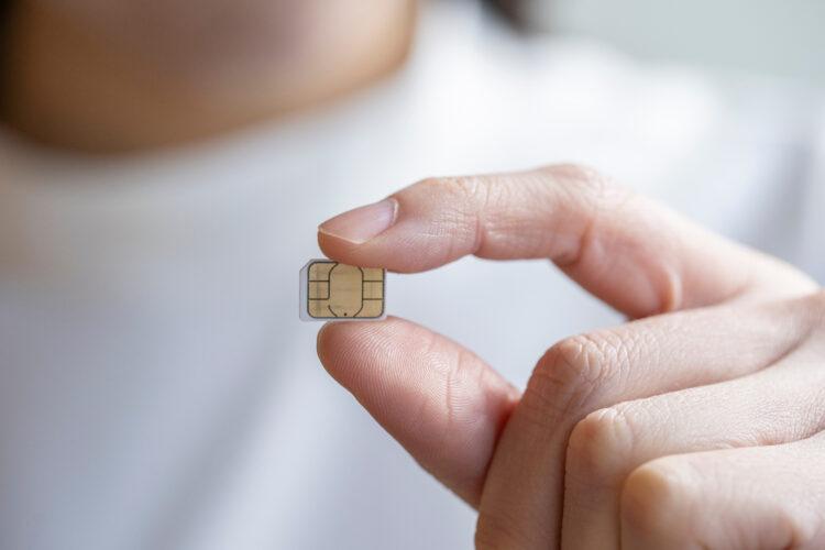 female hand holding a defective sim card that could be the reason why your phone hangs up after 8 hours