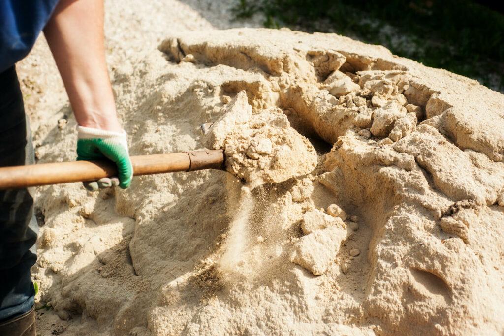 A person shovelling sand