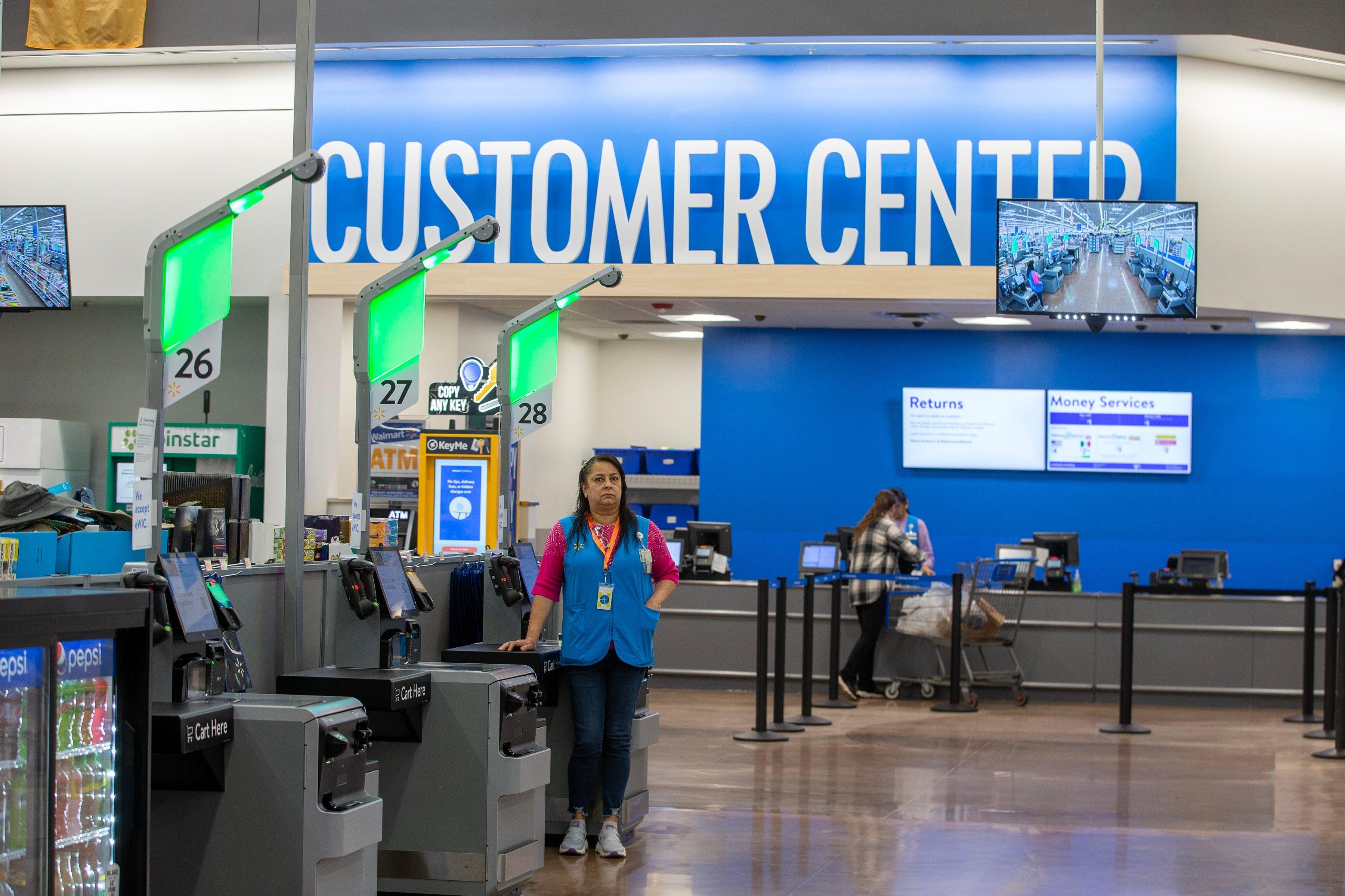 Francisca Pena of Freehold, sales associate, assists customers with new self-checkout kiosks as Walmart hosts a grand reopening celebration and unveils the newly renovated store in Freehold Township, N.J., on April 28.