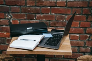 An optimal PI workdesk- with a laptop, notebook, and handbag