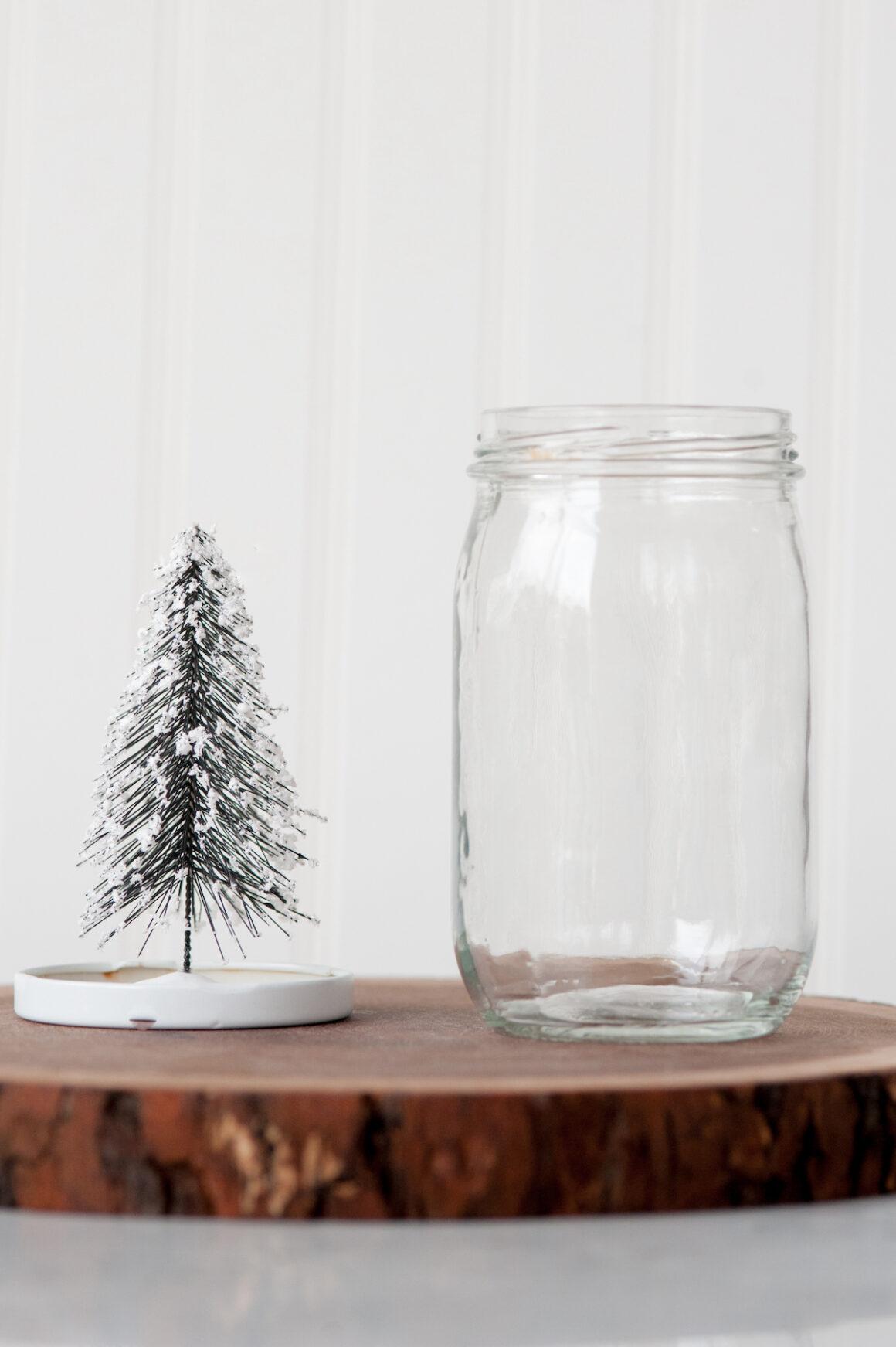 Tinsel glitter in a mason jar held by hand while making snow globes