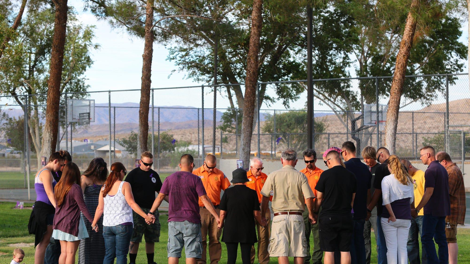 Family, friends, fellow Marines, community members, and search and rescue personnel hold hands in a circle as a prayer is said during a vigil in memory of Erin Corwin at Luckie Park in Twentynine Palms on Monday.