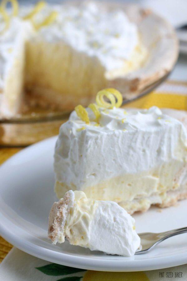 This is an up close view of a single bite of lemon meringue pie on a fork ready to be devoured.